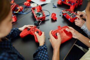 Persons Holding a Red and Black Remote Controllers