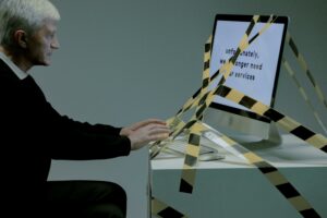 Man typing on computer which is tied with a tape